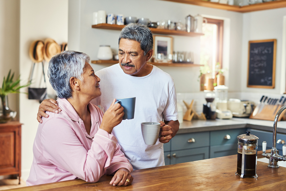 Aging couple smiling drinking coffee together