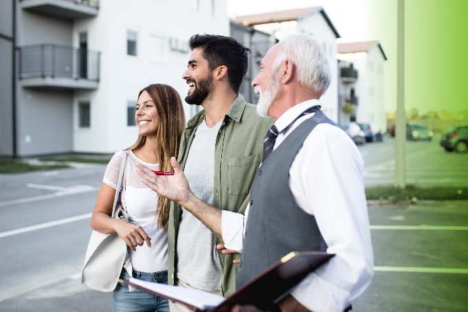 Realtor standing on the street showing a couple a home