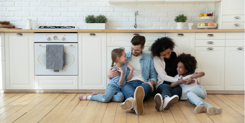 Smiling mom and dad renters rest in own house with children next to natural gas appliances