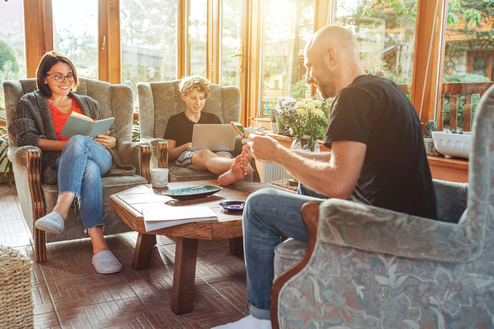 Family sitting in their sun room surrounded by windows