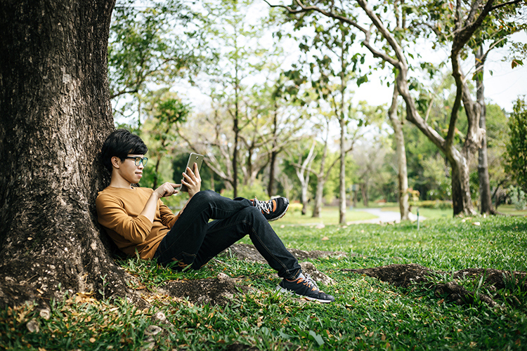 Guy on device under a tree