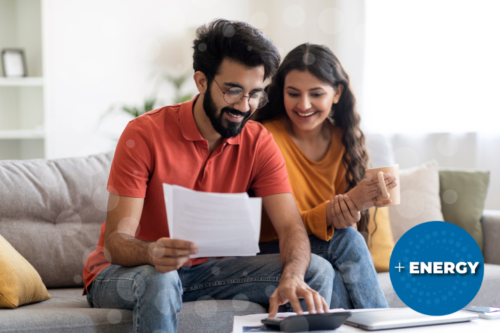 Value_WebGraphic_2025 Smiling couple reviewing a document together on a couch with a laptop.