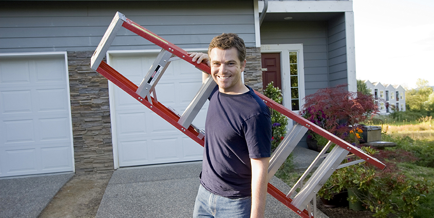 Man carrying ladder outside